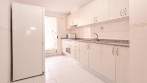 A kitchen with white cabinets, a microwave, and a sink. - Apartamentos Marblau Las Alondras (Gandia)