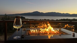 A glass-top table with a fire feature and a glass of white wine, overlooking a lake and mountains. - NO BETTER VIEW THAN THIS (Island Park)