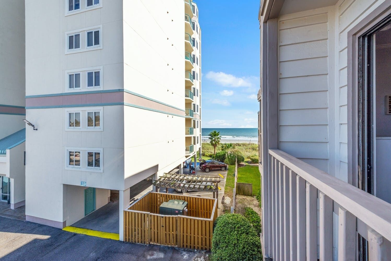 Un immeuble à plusieurs étages doté de balcons donnant sur une plage.