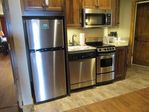 Microwave, dishwasher, cleaning supplies, dining tables