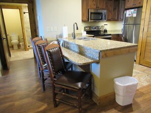 Microwave, dishwasher, cleaning supplies, dining tables
