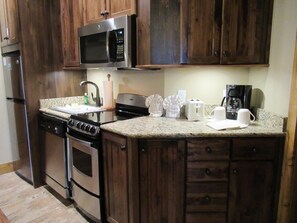 Microwave, dishwasher, cleaning supplies, dining tables