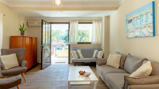 A living room with a sofa, armchairs, a coffee table, and a painting on the wall. - Entheos City Center (Argostoli)