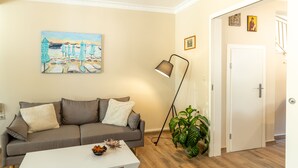 A living room with a sofa, a coffee table, a lamp, and a painting on the wall. - Entheos City Center (Argostoli)