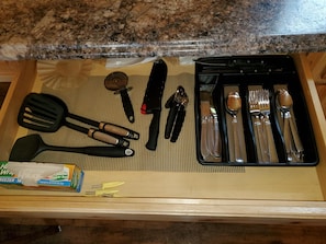 Kitchen essentials at your fingertips, including a spatula, knife, scissors, can opener, and silverware.