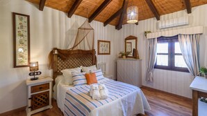 A cozy bedroom with a wooden bed, a bedside table with a lamp, and a window with curtains. - Finca El Albero Carratraca by Ruralidays (Málaga)
