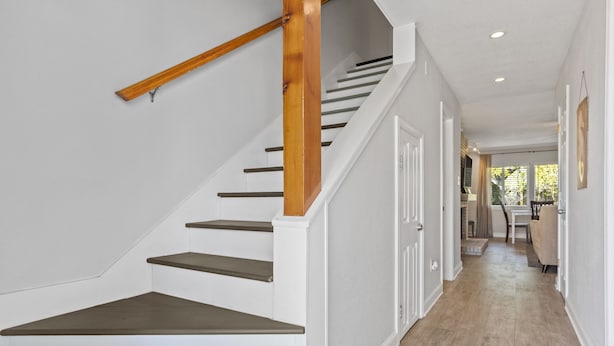 Un escalier avec des rampes en bois et des murs blancs.