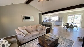 A spacious living room with a beige sofa, a wooden coffee table, and a patterned rug. - Waterfront house with private dock and boat slip (Stigler)