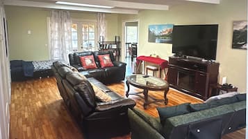 A living room with a sofa set, a television, and a fireplace.