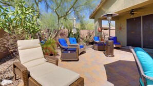 An outdoor patio with wicker furniture, a ceiling fan, and a pergola.