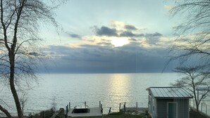 Une vue sur le lac avec un quai, un petit abri et une zone délimitée par une clôture.