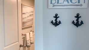 Un pasillo con una puerta blanca, un cuadro enmarcado, un cartel que dice