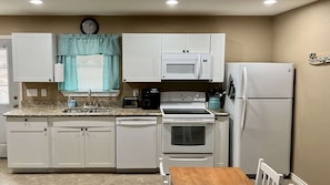 Enjoy cooking in this well-lit kitchen with a stainless steel range, microwave, and coffee maker.