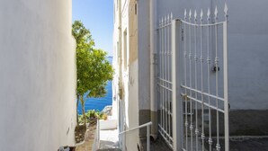 A narrow stairway leading to a gated entrance with a view of the sea. - Mareblù in Praiano centre (Praiano)
