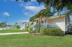 Une rangée de maisons de plain-pied, chacune dotée d’un porche et d’un petit jardin devant.