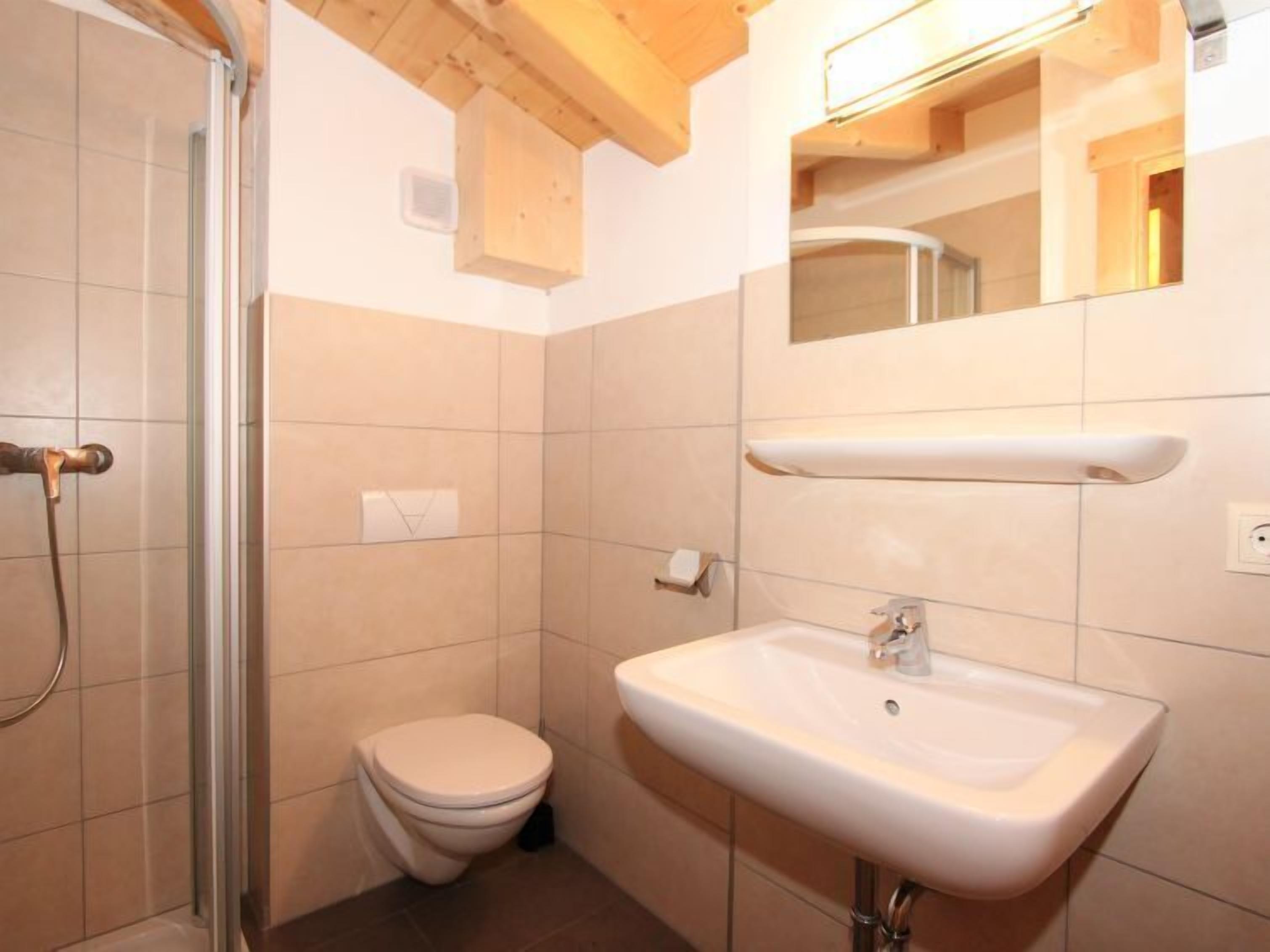 Un baño pequeño con inodoro, lavamanos y ducha.