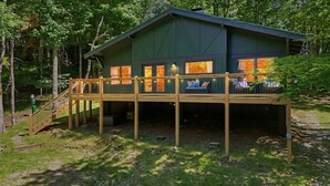 Une cabane dotée d’une terrasse, d’un escalier et d’un porche.