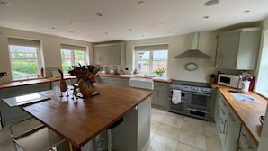 A spacious kitchen with a central island, ample counter space, and a large window providing natural light.