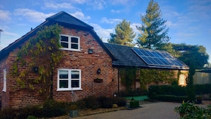 A brick house with a sloped roof and solar panels.