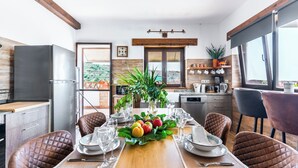 A modern kitchen with a dining area set for six. - Villa for 4 with feature pool & great reviews (Bedar)