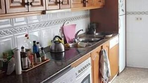 A kitchen with wooden cabinets, a washing machine, and a sink. - 3 Bed Flat - Sleeps 5 - Parking - Wifi (Tarifa)
