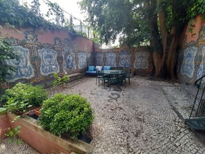 Relax in a serene courtyard surrounded by lush greenery and intricate tile patterns.