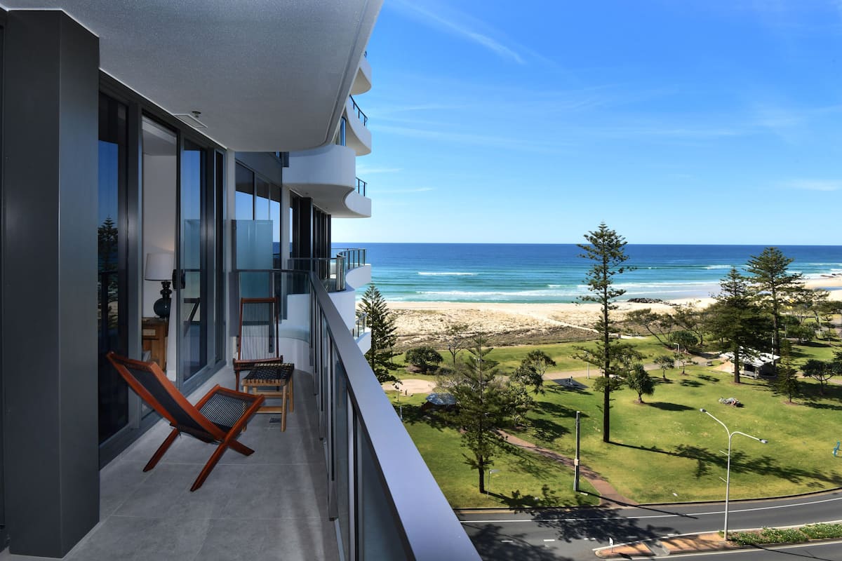 A balcony with a view of the beach and ocean.