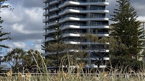 A multi-story building with balconies, surrounded by grass and trees. - X Kirra Apartments (Coolangatta)