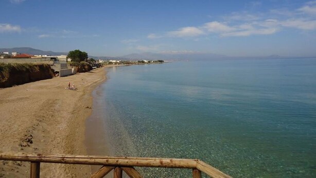 A beach with clear water, a sandy shore, and a wooden railing. - 3 Bedrooms Apartment With Sea View and Swimming Pool (Rethymno)