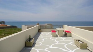 A rooftop terrace with a patterned floor, seating area, and a view of the sea. - 3 Bedrooms Apartment With Sea View and Swimming Pool (Rethymno)