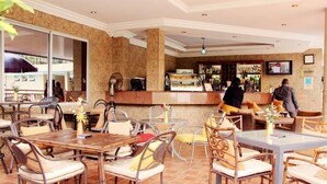 A restaurant with outdoor seating, a bar area, and a television screen. - Room-chelsea Hotel - Guest Room (Abuja)