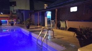 A pool area with a ladder, potted plants, and a chair. - Room-divine Fountain Hotel - Guest Room (Lagos)