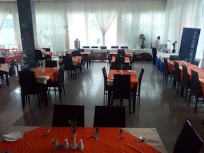 A dining area with tables set for multiple people, a waiter in the background, and a banner with 'Golden Royale' text.