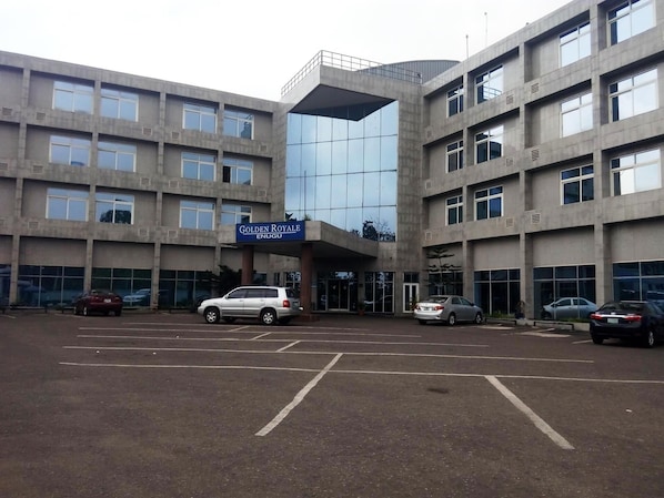 A multi-story building with a sign reading 'Golden Royale Enugu.'