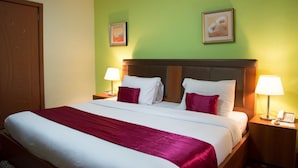A hotel room with a bed, two nightstands, a door, and two wall-mounted lamps. - Room-grand Ibro Hotel - Guest Room (Abuja)