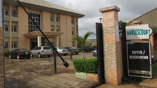 Entrada de un hotel con un letrero que dice 'Harlescourt Suites / Reservación'.