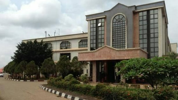 A building with a modern architectural style, featuring large windows and a prominent entrance. - Room-nelrose Hotel - Class King (Asaba)