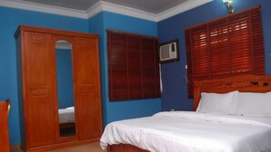 Un dormitorio con cama, armario de madera y aire acondicionado instalado en la pared.