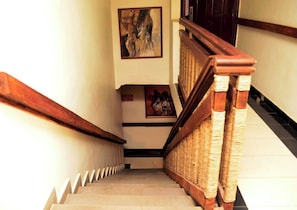 Eine Treppe mit einem hölzernen Geländer und Korbkorbspindeln.