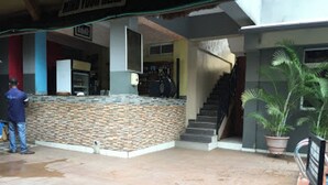 A lobby with a stone counter, a staircase, and a potted plant. - Room-aotel Hotel - Guest Room (Lagos)
