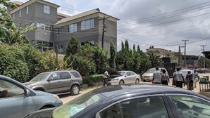 A parking lot with several cars and a building in the background. - Room-aotel Hotel - Guest Room (Lagos)