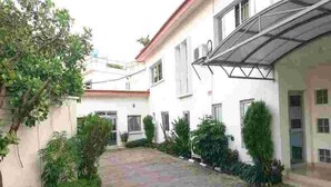 Un patio con un sendero empedrado, rodeado de edificios con paredes blancas y techos rojos.