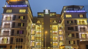 A multi-story hotel with illuminated signage reading 'THE WELLS CARLTON.' - Room-the Wells Carlton - Guest Suite (Abuja)