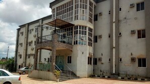 A multi-story building with a central staircase, a covered entrance, and multiple windows. - Room-wetland Hotels, Ibadan-guest Room (Ibadan)