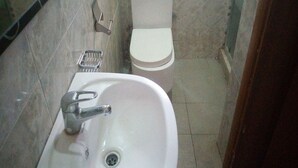 A bathroom with a white sink, toilet, and a metal handrail. - Room-wetland Hotels, Ibadan-guest Room (Ibadan)