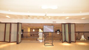 A spacious lobby with a high ceiling, recessed lighting, and a central television screen. - Room-world Lilies Hotel-guest Room (Ibadan)