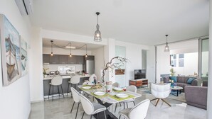 A modern open-plan living space with a dining area, kitchen, and seating area. - Villa Prol26, Stunning 3bdr Protaras Villa With Pool, Close to Fig Tree Bay (Paralimni)