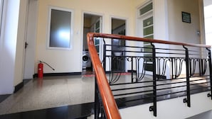 A staircase with a black metal railing and a wooden handrail. - Hillside Homestay Hue - Top Apartment (Hue)