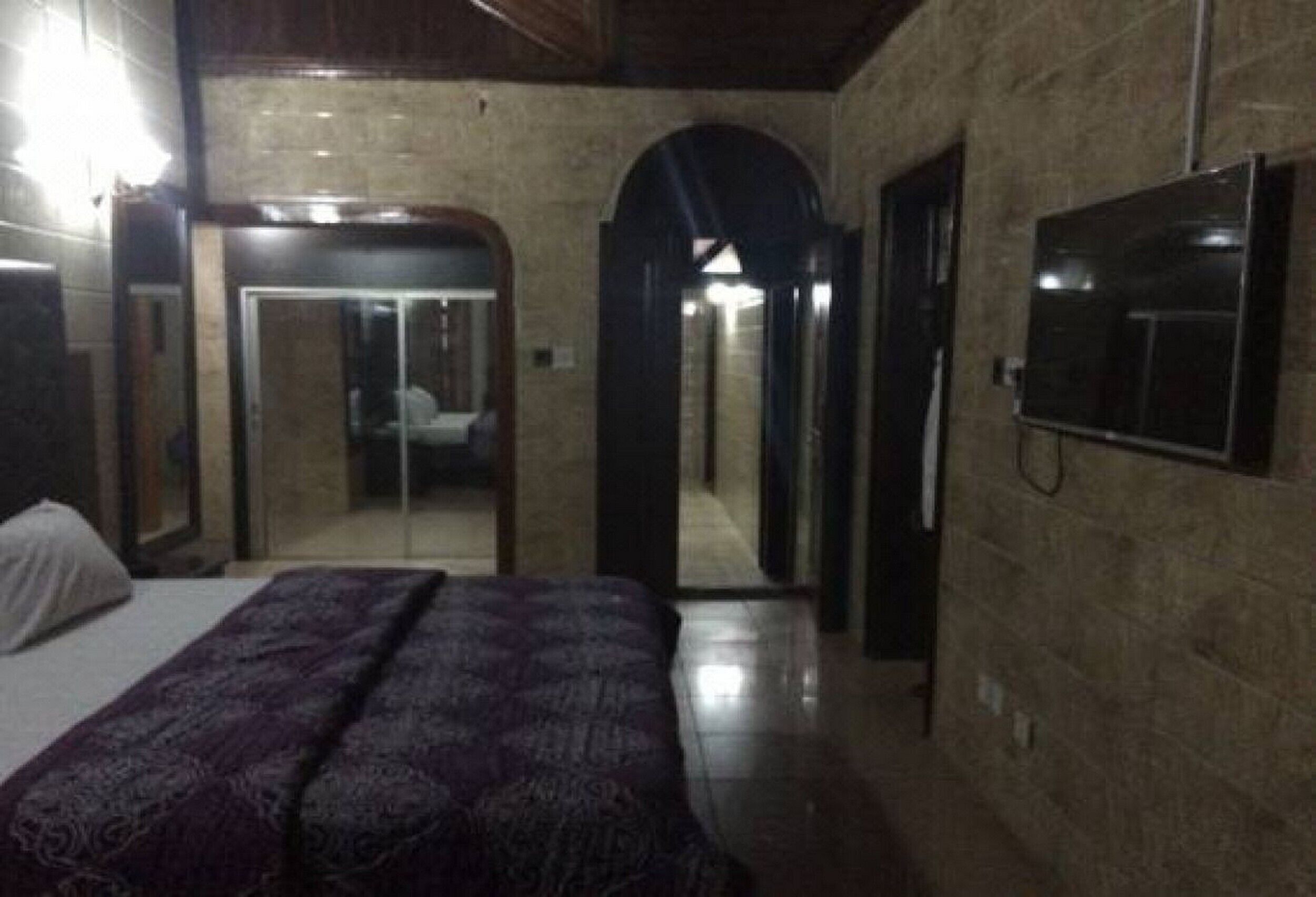 Una camera da letto con un letto, uno specchio e una porta che dà su un bagno.