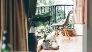 A balcony with a chair, potted plants, and a view of greenery. - Hillside Homestay Hue - Triple Room top Apartment (Hue)